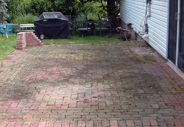Dirty moss-stained driveway before cleaning